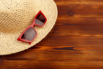 Sunglasses and straw hat on the wooden floor at the beach, summer concept. - Image