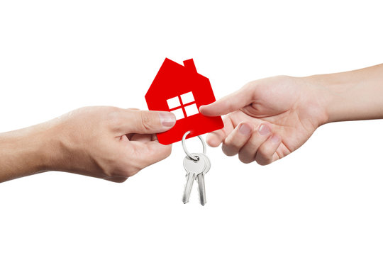 Hands sharing a small red house with keys, isolated on white background