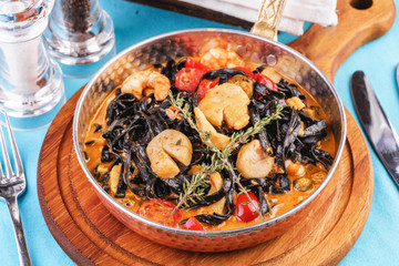  Mediterranean black pasta with shrimps, tomatoes, dumplings, rosemary and mushrooms