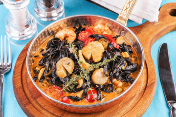  Mediterranean black pasta with shrimps, tomatoes, dumplings, rosemary and mushrooms