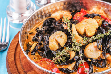  Mediterranean black pasta with shrimps, tomatoes, dumplings, rosemary and mushrooms