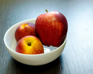 Two red peaches and a large Apple on a white plate on the table. Concept cholesterol reduction in...