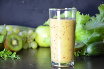 Health Drink and Smoothie Diet. Green fruits and vegetables on a black background. Kiwi, green grapes, lettuce, zucchini, cucumbers, green apple, parsley with spinach top view selective focus