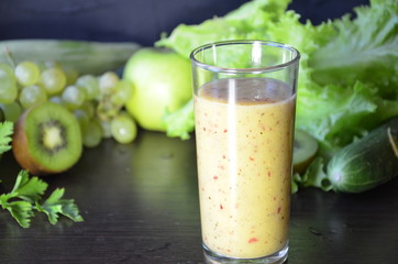Health Drink and Smoothie Diet. Green fruits and vegetables on a black background. Kiwi, green grapes, lettuce, zucchini, cucumbers, green apple, parsley with spinach top view selective focus