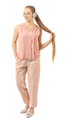 Beautiful young woman listening to music on white background