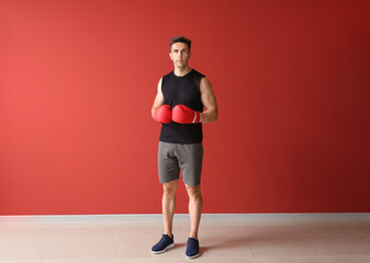 Sporty male boxer on color background