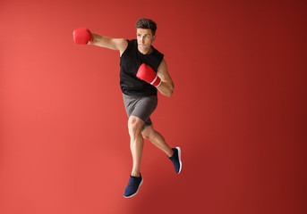 Sporty male boxer on color background