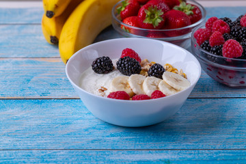 Muesli with yogurt and fruit on wooden table. 