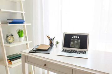 Calendar on screen of laptop in room