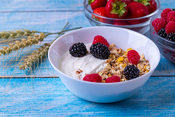 Muesli with yogurt and fruit on wooden table. 