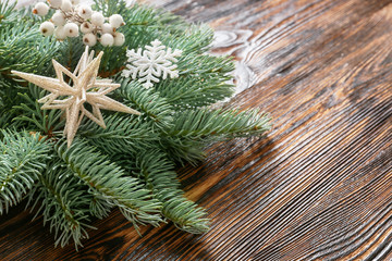 Christmas tree branch and decor on wooden background, closeup