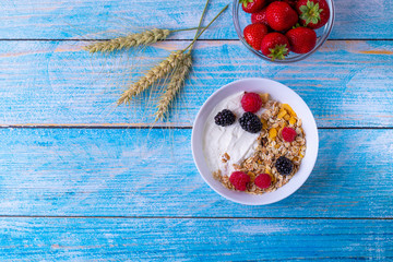Muesli with yogurt and fruit on wooden table. 