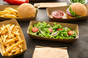 Containers with delicious food on grey background
