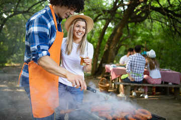 Friends having a barbecue party in nature while having fun