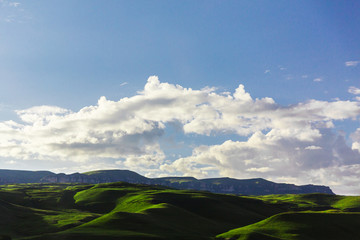 Fototapeta na wymiar Green hills on blue sky background. Beautiful mountain landscape