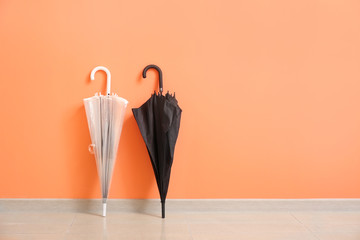 Stylish umbrellas near color wall