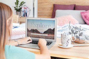 Woman with laptop visiting travel agency website at home