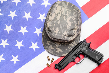 Military cap and gun on USA flag