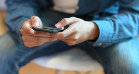 Young businessman hand's typing on his smartphone