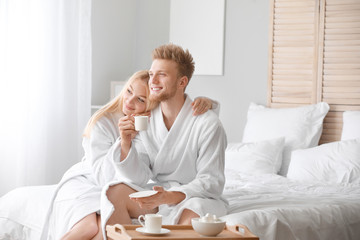 Morning of happy young couple in bedroom