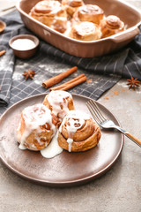 Plate with tasty cinnamon buns on table