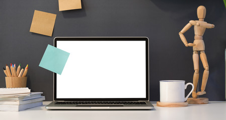 Dark stylish work place with open blank screen laptop