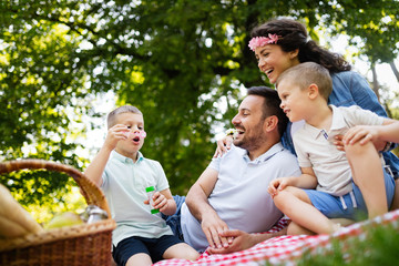 Fototapeta premium Family with children blow soap bubbles outdoors