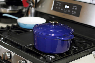 Porcelain enameled Dutch oven and skillet on the stove top in a home kitchen.