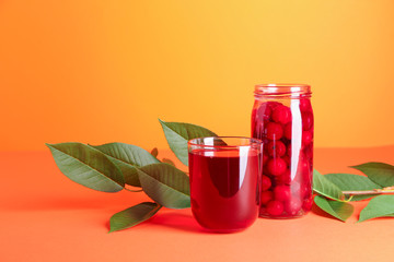 Fresh cherry and juice on color background