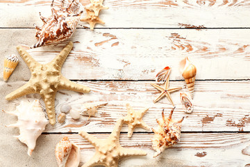 Beautiful sea shells and starfish on wooden background