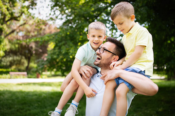 Father and his sons playing and hugging outdoor