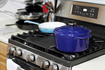 Porcelain enameled Dutch oven and skillet on the stove top in a home kitchen.