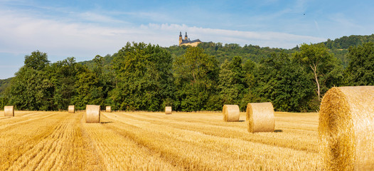 Ein Feld mit Ballen aus Stroh im Hintergrund Kloster Banz, Panorama