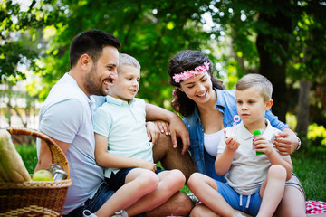 Happy young family enjoying picnic in nature