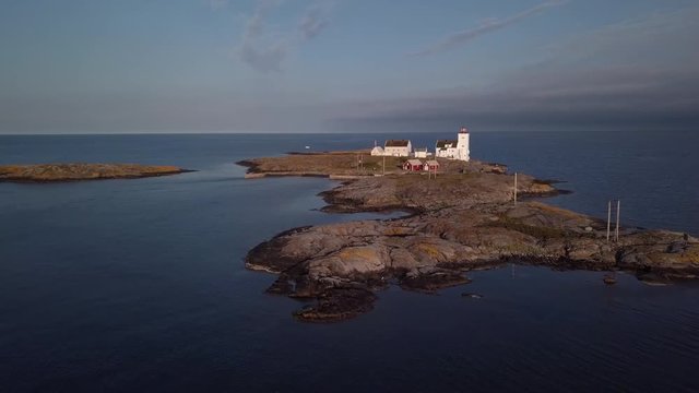 Aerial, drone shot, towards the Homborsund Lighthouse, on the Store Gronningen island, on a sunny, summer evening, in Grimstad, Aust-agder, Norway