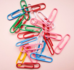 multicolored paper clips on a pink background. The concept is time to school.