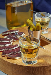 whiskey in two glasses and sliced jerky with spices on the oak surface. Close up.