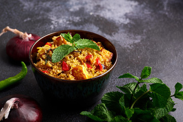 vegetarian paneer biryani at black background. paneer biryani is traditional veg indian cuisine dish with paneer cheese, basmati rice, masala, chili pepper, mint and many another spices. Copy space