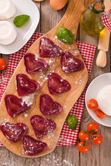 Red heart ravioli with tomato, mozzarella and basil.