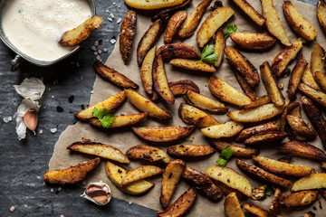 Delicious potatoes with rosemary on parchment, closeup