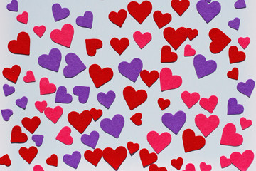 Red, pink and purple felt hearts on blue background