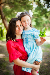 Obraz premium cute little girl and her mother having fun on the grass in a Sunny Park
