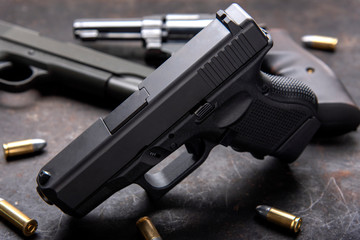Gun with ammunition on dark background. 
