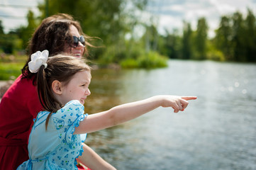 cute little girl and her mother having fun on the grass in a Sunny Park