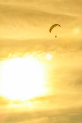 Obraz premium sunset with paragliders pilot flying over clouds