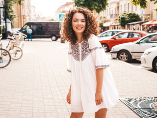 Portrait of beautiful smiling model with afro curls hairstyle dressed in summer hipster white...