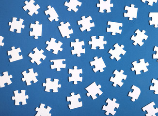 Many scattered puzzles on blue background top view