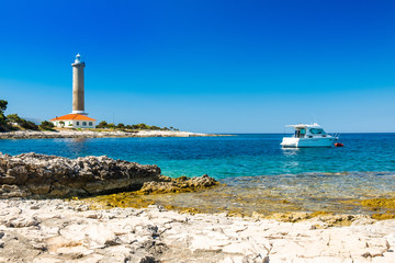 Croatia, island of Dugi Otok, old lighthouse of Veli Rat on the stone shore, beautiful seascape in foreground