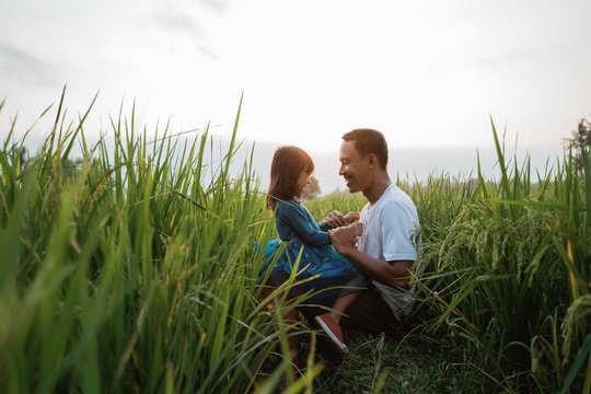 daughter and father bonding outdoor enjoy in the rice field playing and embracing each other