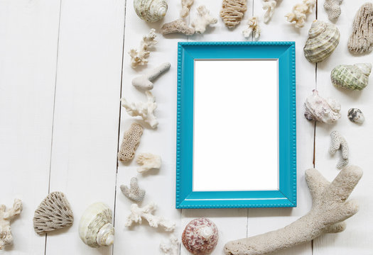 Blue Wooden photo frame on a white wood floor and have Shells and coral reefs.